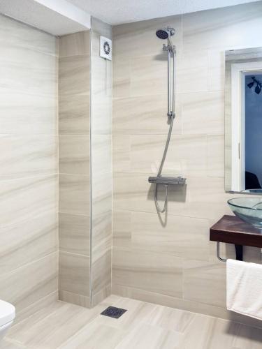 a shower with a glass door in a bathroom at Студио Черно и Бяло in Sandanski