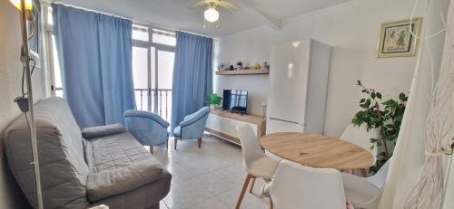 ein Wohnzimmer mit Sofa und Tisch in der Unterkunft BENIDORM, Las Damas, primera línea de playa de Levante in Benidorm
