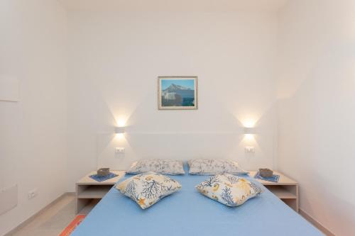 a bedroom with a blue bed with two pillows at Domo Davide in San Teodoro