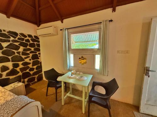 a room with a table and chairs and a window at Captans Stay in Lonavala
