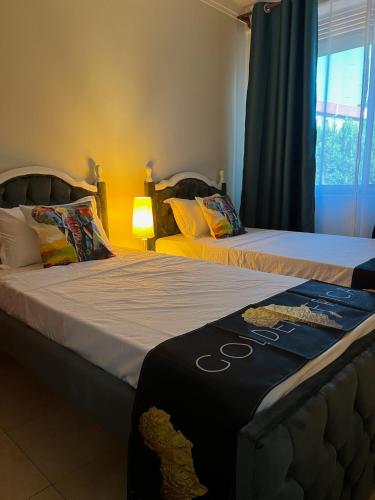 two beds sitting next to each other in a room at Kamona Living 3 Zimmer Apartment in Namugongo