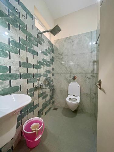 a bathroom with a toilet and a sink at Karkera's Beach Stay in Malpe