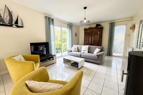 un salon avec un canapé et une télévision dans l'établissement Villa avec piscine chauffée - En pleine nature, à Sainte-Hélène