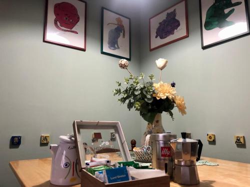 un tavolo con uno specchio e un vaso di fiori di Due Calzini a Roma