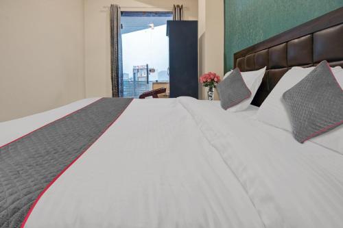 a bedroom with a large white bed with a window at Collection O Aloft in Jaipur
