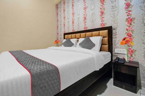 a bedroom with a large bed and a vase of flowers at Collection O Aloft in Jaipur