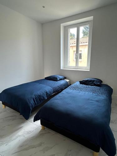 deux lits dans une chambre avec une fenêtre dans l'établissement Appartement T3, Wi-Fi ,climatisé 2ème étage et dernier étage, à Marseille