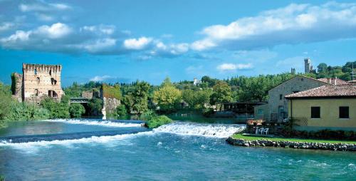 a river with rapids in the middle of a town at Casa Magenta Apartment 4 in Valeggio sul Mincio