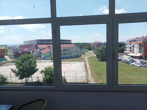 a window with a view of a parking lot at Rita's - family apartment by the sea in Primorsko