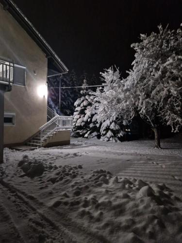a snow covered sidewalk next to a building at night at Apartman Potok in Livno