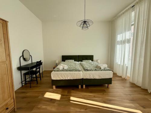 a bedroom with a bed and a desk in it at Apartament Mariański in Lądek-Zdrój