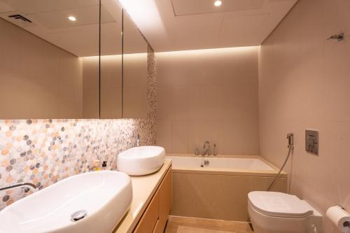 アブダビにあるSustainable Mayan Escape 2BR with Beach Accessの洗面台、浴槽、トイレを備えたバスルーム