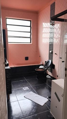 a bathroom with a toilet and a window at Hostel & Pousada SANTOS PRAIA in Santos