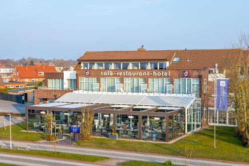a building with a sign that reads cafe restaurant hotel at Hotel Regina Maris in Norddeich