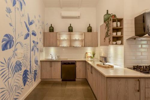 a kitchen with wooden cabinets and blue and white tiles at LostTraveller 3BHK Villa with a view Private Pool in Saligao LT347 in Saligao