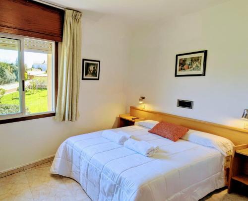 a bedroom with a large white bed and a window at Restaurante y Hostal San Paio in Santiago de Compostela