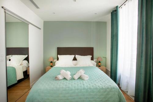 une chambre avec un lit avec deux serviettes dessus dans l'établissement Paris 2 - Vendôme - Rue Volney - 2 rooms, à Paris