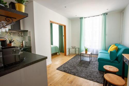 un salon avec un canapé bleu et une cuisine dans l'établissement Paris 2 - Vendôme - Rue Volney - 2 rooms, à Paris