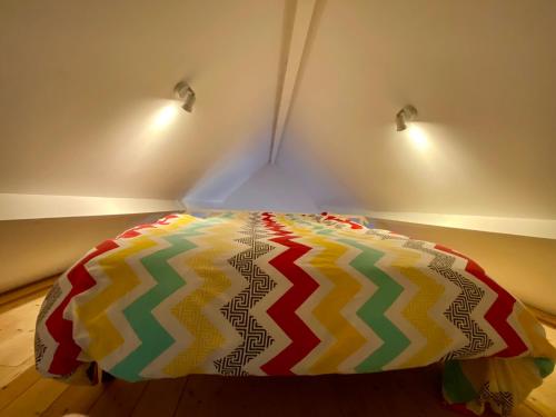 un lit coloré dans une chambre avec deux lumières dans l'établissement La petite maison rouge, à Cucq