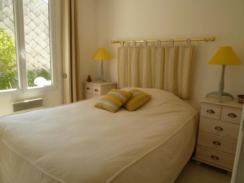 a bedroom with a white bed with two pillows on it at Baie de Somme Cayeux sur mer in Cayeux-sur-Mer