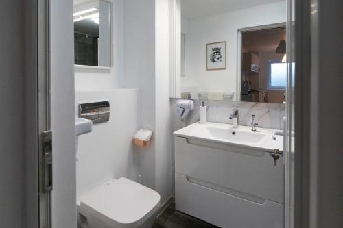 ein weißes Badezimmer mit Waschbecken und Toilette in der Unterkunft Aquarium Apartament in Buzău