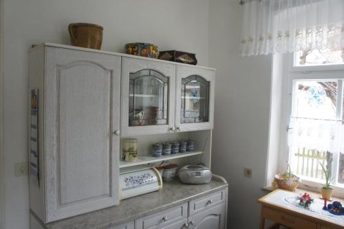 a kitchen with white cabinets and a window at apartment Anna in Wilthen
