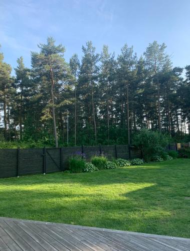 a yard with a fence and green grass at Mysigt boende i Åhus med egen ingång, terass, wifi, tvättmaskin & parkering! in Åhus