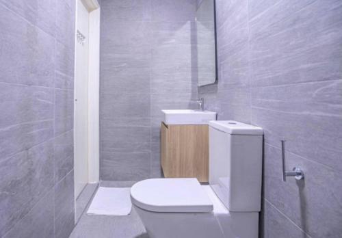 Un baño con un inodoro blanco y un lavabo. en Revo, Aurora-Pavilion 22, en Kuala Lumpur