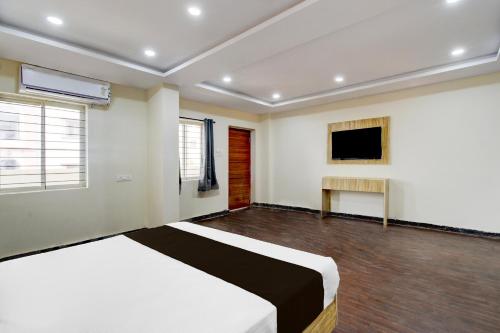 a bedroom with a bed and a television in it at FabHotel Cube in Maula Ali
