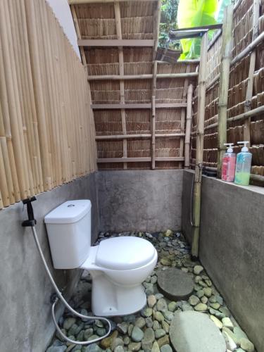 a bathroom with a toilet on a rocky ground at Casita Agnes Private Resort in Boac