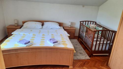 a bedroom with a large bed and a crib at Apartman Ružica in Tomislavgrad