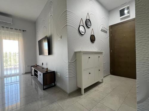a room with a white wall with clocks on the wall at DIS LUX Apartments in Radanovići