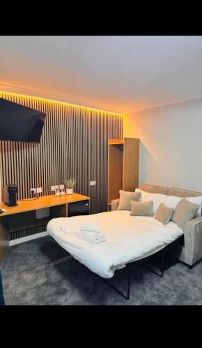 a bedroom with a large bed and a desk at Thomas Arms Hotel in Llanelli
