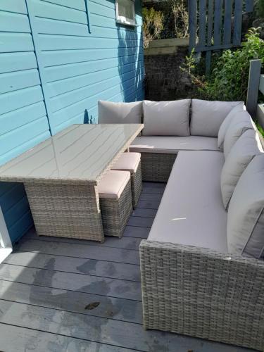 a couch and a table on a patio at Wee Blue Hoose in Dalmally