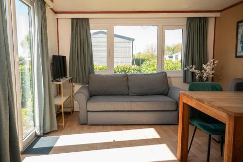 a living room with a couch and some windows at Leeuwendamme in Serooskerke