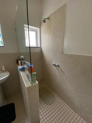 a bathroom with a shower and a sink at Wonderful Guest house in Durban