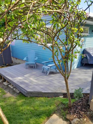 a patio with two chairs and a table and a tree at Wee Blue Hoose in Dalmally
