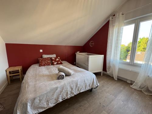 - une chambre avec un lit aux murs rouges et une fenêtre dans l'établissement Le Racing Lodge - 4pers - Wi-fi, à La Bazoge