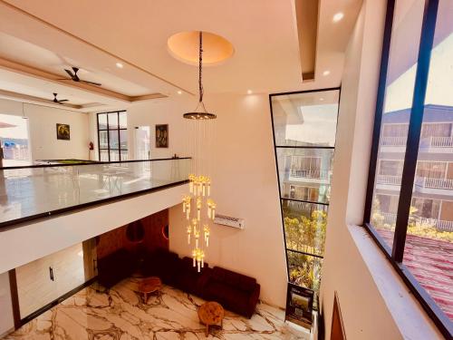 a lobby with a marble floor and a chandelier at The Woods Farmhouse Resort, Jim Corbett - A beautiful wellness resort in the lap of nature in Rāmnagar