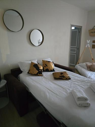 - une chambre avec un grand lit et deux miroirs sur le mur dans l'établissement Escapade cathare, à Carcassonne