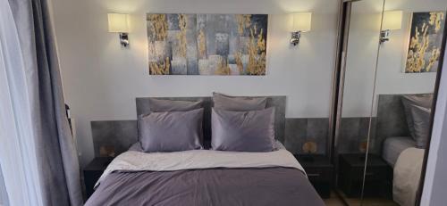 a bedroom with a bed and a painting on the wall at Suite Prestige Paris-La Défense Balcon-Terrasse in Courbevoie