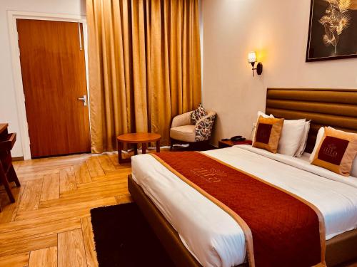 a hotel room with a large bed and a chair at The Woods Farmhouse Resort, Jim Corbett - A beautiful wellness resort in the lap of nature in Rāmnagar