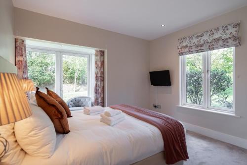 a bedroom with a large white bed with two windows at Large home to sleep 8 in Kenmare. Free use of pool onsite in Kenmare