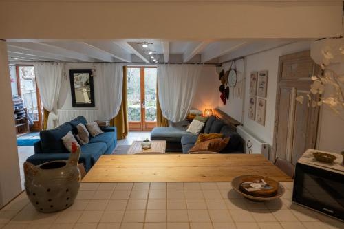 a living room with a blue couch and a table at Rives de Bourges in Burzet