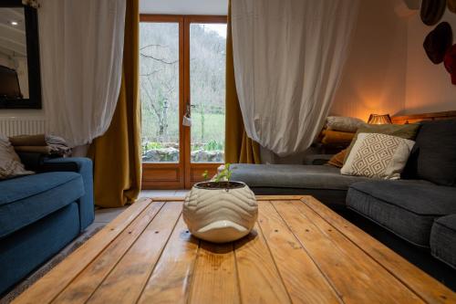 a living room with a couch and a wooden table at Rives de Bourges in Burzet