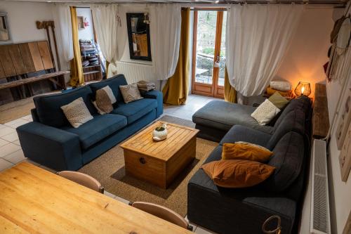 a living room with blue couches and a table at Rives de Bourges in Burzet
