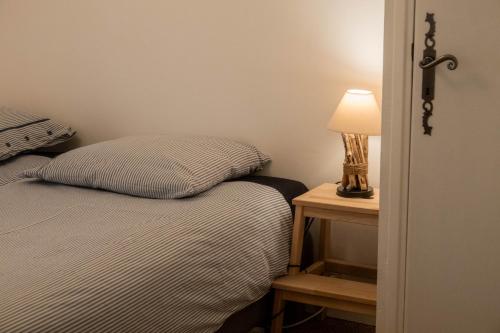 a bedroom with a bed and a lamp on a night stand at Rives de Bourges in Burzet