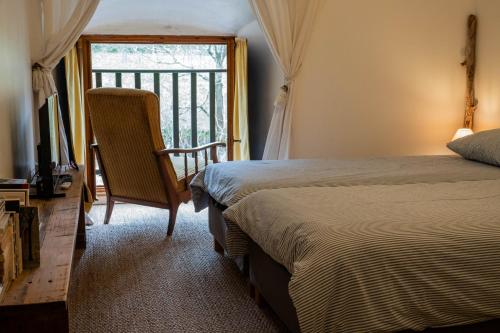 a bedroom with a bed and a television and a window at Rives de Bourges in Burzet