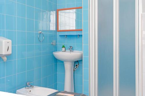 a blue bathroom with a sink and a mirror at A Casa di Amici in Palermo