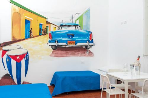 a painting of a blue car on a wall at A Casa di Amici in Palermo